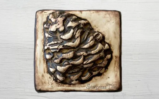 Textured clay piece resembling a pinecone, showcasing intricate details and earthy colors. Ideal for decorative or craft purposes.