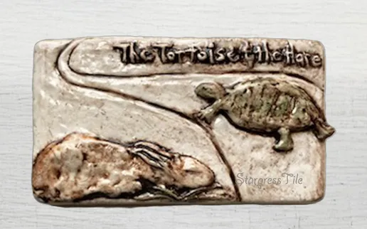 A ceramic tile depicting the classic fable "The Tortoise and the Hare," featuring a tortoise and hare on a winding path, symbolizing perseverance over arrogance.