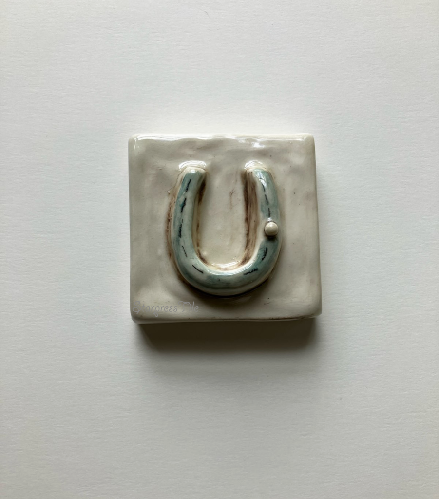 Horseshoe ceramic art tile, hand painted in teal and brown highlight glaze.